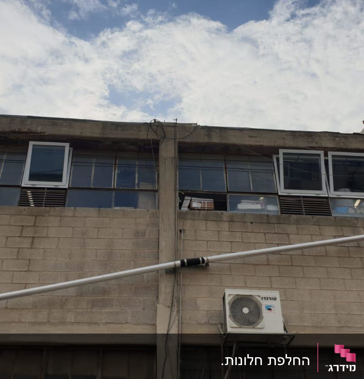 חלונות עם תריסים פתוחים בבניין תעשייתי